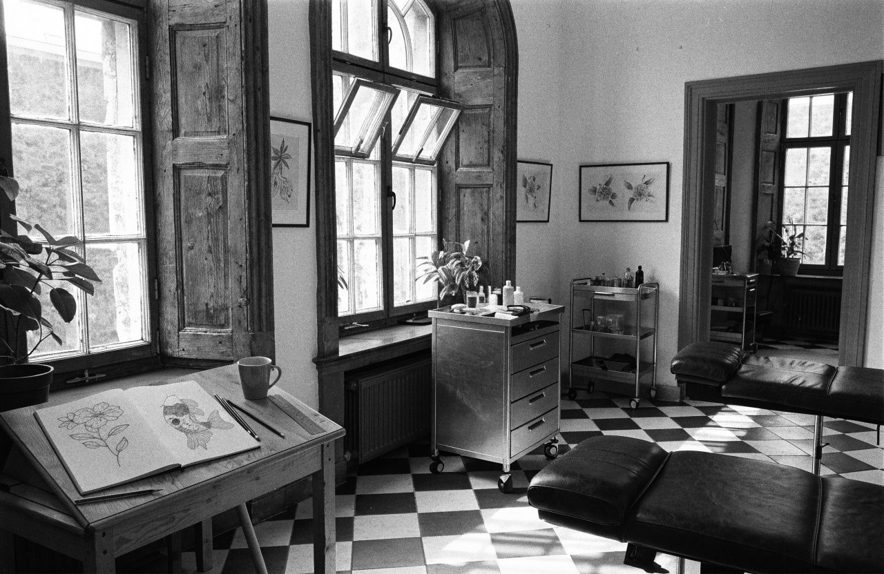 A drawing desk by the window, an open sketchbook of flowers and a koi